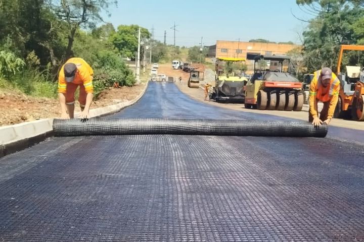 Aplicação Spalla — dois operários instalando geogrelha em rodovia