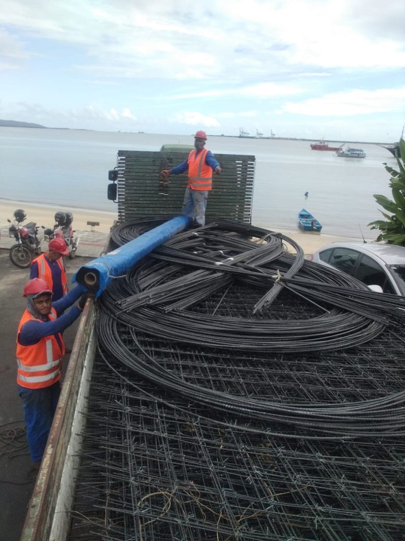 Carregamento de telas e vergalhões de FRP em obra à beira-mar